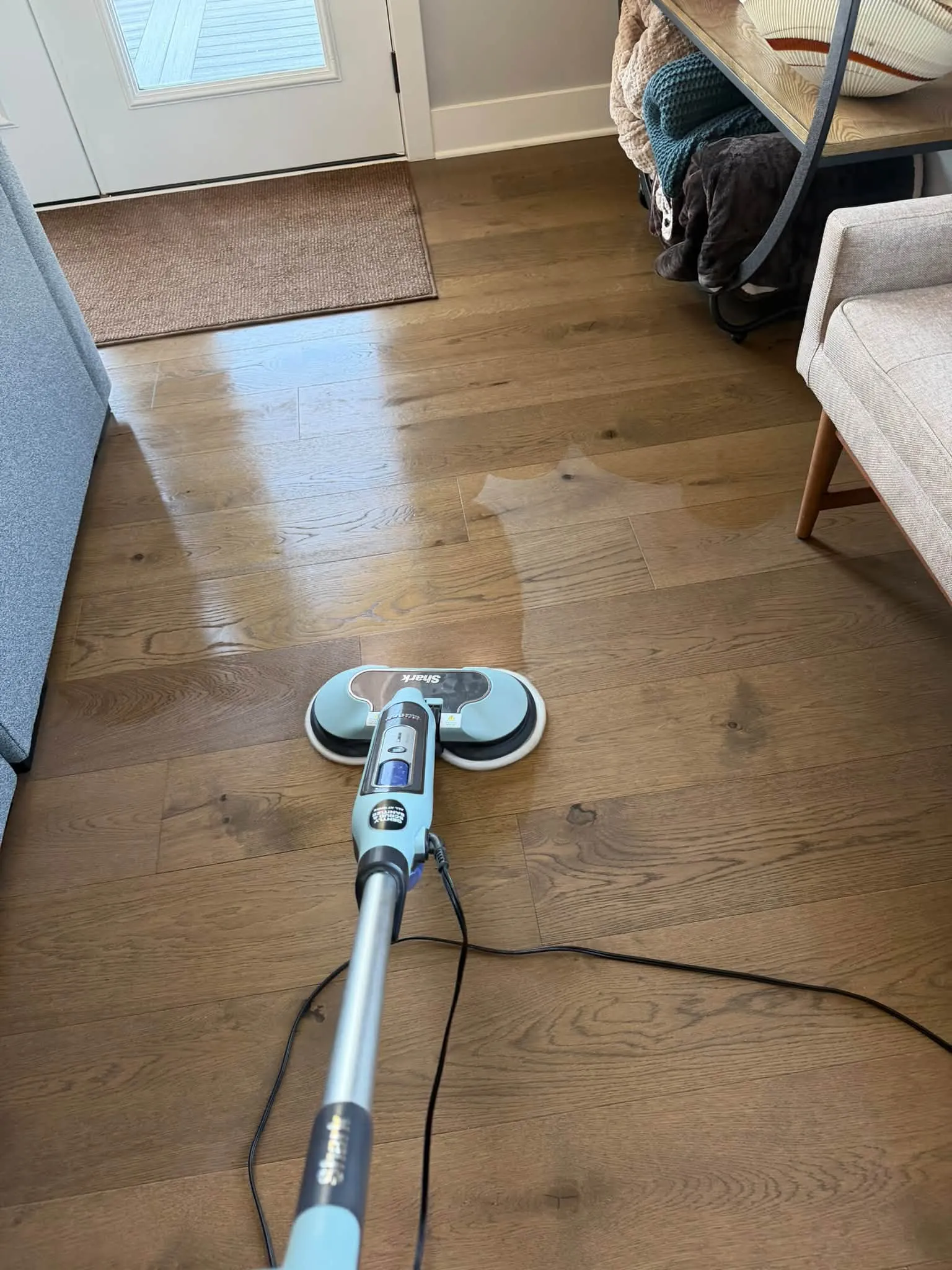 A floor scrubber running over the hardwood floor near the kitchen door