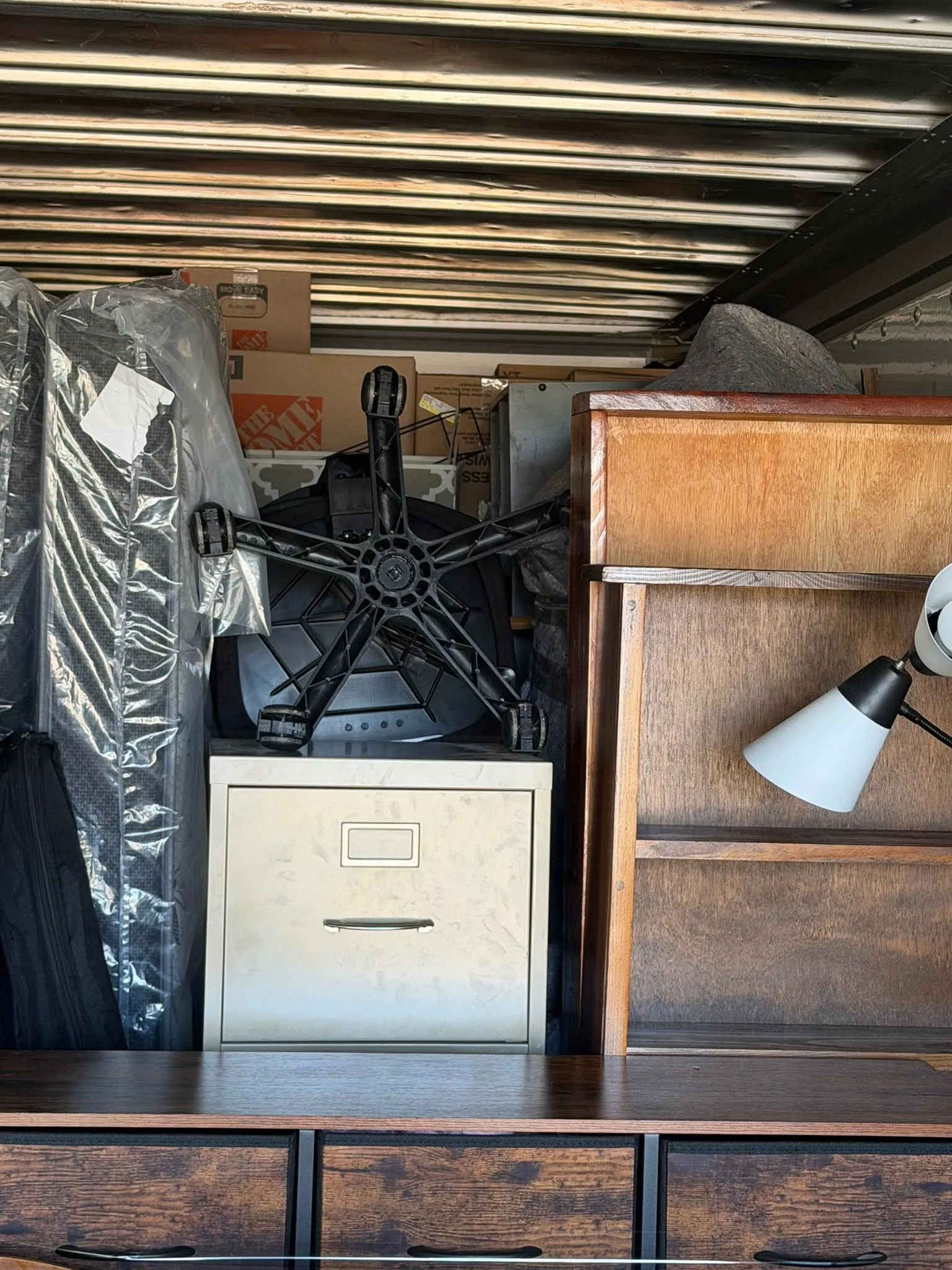 Inside the box truck: wrapped furniture, a filing cabinet, a desk chair and a dresser packed floor to ceiling