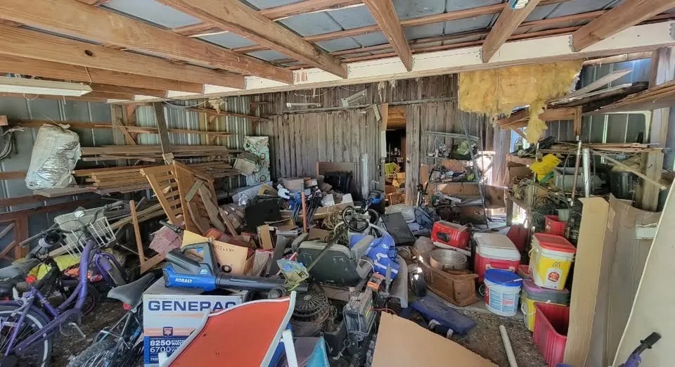 A garage packed to the rafters with bicycles, a generator, boxes, bins and furniture