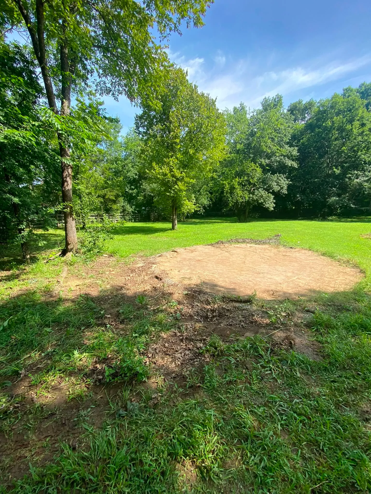 The same yard after the pool was torn out, a bare circle of dirt in the grass