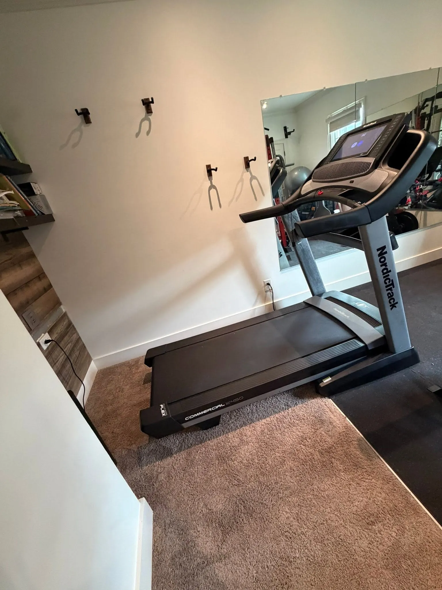 The treadmill rebuilt and standing in a home gym with a mirror wall