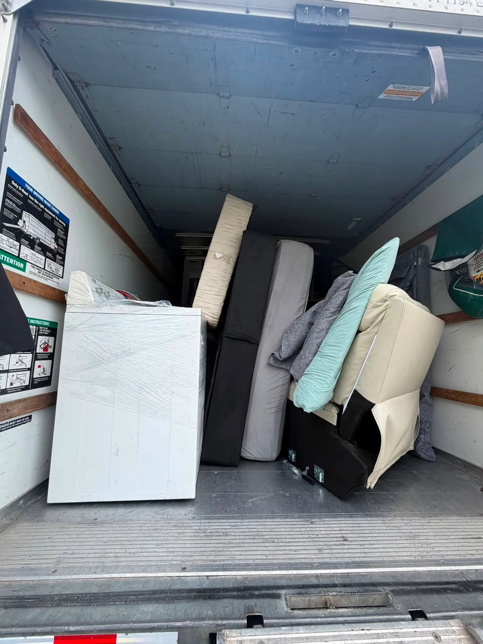 A washer, a sofa and cushions loaded into the back of the box truck
